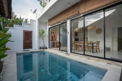 a swimming pool in front of a house at Villa Kainara 2 - Cozy villa in center of Seminyak in Seminyak
