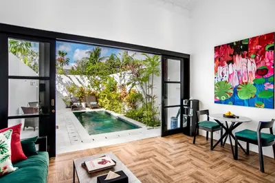a living room with a pool and a table and chairs at Villa Balik I Seminyak in Seminyak
