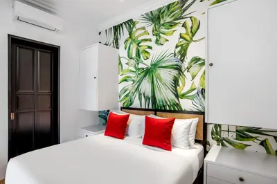a bedroom with a large white bed with red pillows at Villa Balik I Seminyak in Seminyak