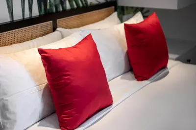 a bed with two red pillows on it at Villa Balik I Seminyak in Seminyak