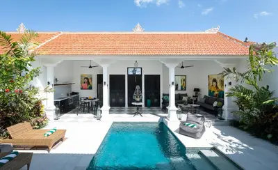 a villa with a swimming pool and a house at Martini Beachside Villa 1 in Canggu