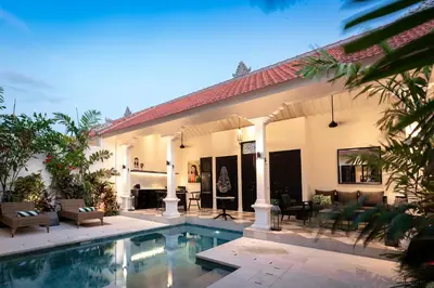 a house with a swimming pool in front of it at Martini Beachside Villa 1 in Canggu