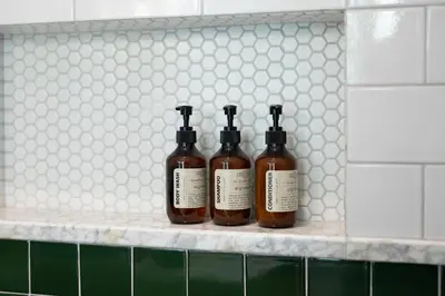 three bottles of wine sitting on a shelf in a bathroom at Martini Beachside Villa 1 in Canggu