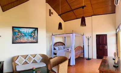 a living room with a bed and a couch at Giri's Villa Jimbaran in Jimbaran