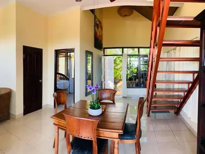 a dining room with a wooden table and chairs at Giri's Villa Jimbaran in Jimbaran