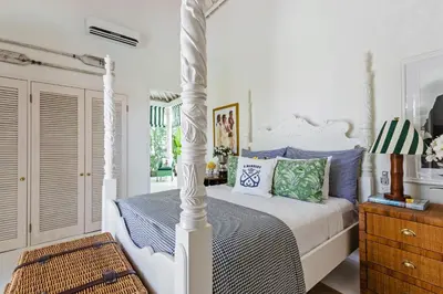 a bedroom with a white bed with blue and green pillows at Pineapple Hill 4 Bed Luxury in Seminyak