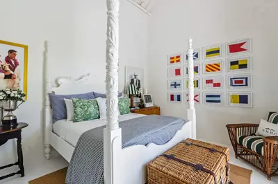 a bedroom with a white bed and some pictures on the wall at Pineapple Hill 4 Bed Luxury in Seminyak
