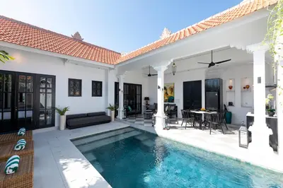 a villa with a swimming pool and a house at Martini Beachside Villa 3 in Canggu