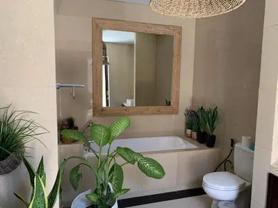 a bathroom with a tub and a toilet and a mirror at Villa Olga in Seminyak