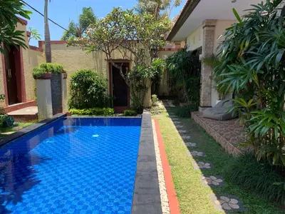 a swimming pool in front of a house at Villa Olga in Seminyak