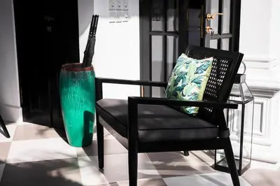 a black chair with a green vase next to it at Martini Beachside Villa 4 in Canggu