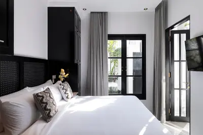 a bedroom with a large white bed and a window at Martini Beachside Villa 4 in Canggu