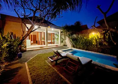 a villa with a swimming pool at night at Villa Majegau 2 Seminyak in Seminyak