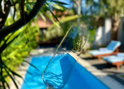 a close up of a blue glass window next to a swimming pool at Villa Majegau 2 Seminyak in Seminyak