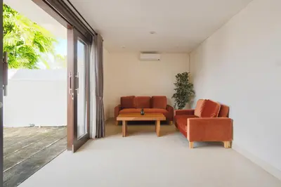 a living room with two chairs and a table at Villa Maxima by Maheswara in Canggu