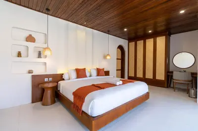 a bedroom with a large bed and a desk at Green Jimbaran Bay Villa in Jimbaran