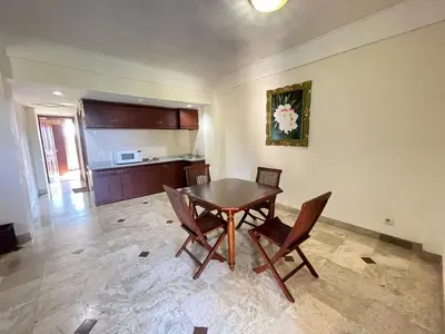 a dining room with a wooden table and chairs at Beach Apartment inside Resort Walking Distance to the beach in Seminyak