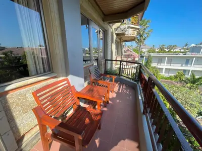 three benches sitting on a balcony of a house at Beach Apartment inside Resort Walking Distance to the beach in Seminyak