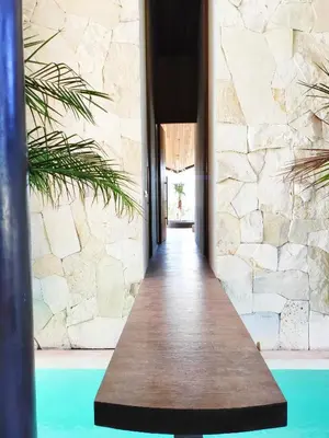a walkway leading to a pool in a house at Villa FEH Bali by House of Winds - Neo Tropical Eden near Canggu in Kerobokan