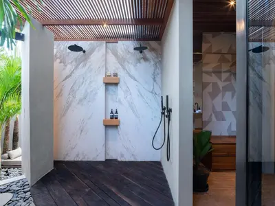 a shower in a bathroom with a marble wall at Villa FEH Bali by House of Winds - Neo Tropical Eden near Canggu in Kerobokan