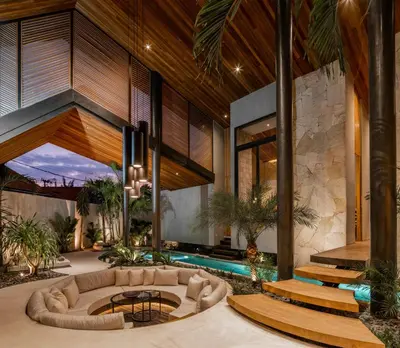 an indoor living room with a couch and a pool at Villa Levante Bali by House of Winds - Tropical Oasis near Canggu in Kerobokan