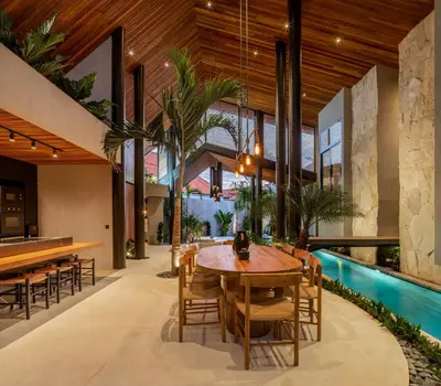 a dining room with a table and chairs and a pool at Villa Levante Bali by House of Winds - Tropical Oasis near Canggu in Kerobokan