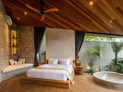 a bedroom with a bed and a bath tub at Villa Levante Bali by House of Winds - Tropical Oasis near Canggu in Kerobokan