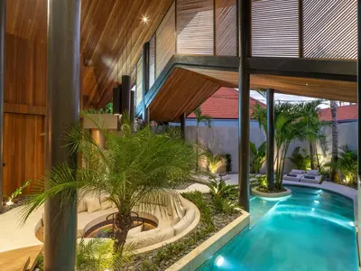 an indoor courtyard with a swimming pool in a house at Villa Levante Bali by House of Winds - Tropical Oasis near Canggu in Kerobokan