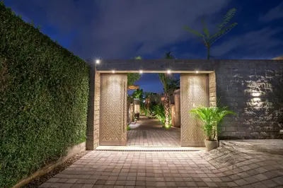 an entrance to a building with a hedge with lights at Sin Nombre Bali - Sauna, Ice Bath & Roof Terrace in Canggu