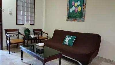 a living room with a brown couch and chairs at Kun's Stay Private Apartments in Seminyak