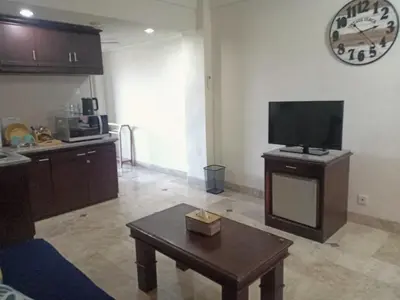 a living room with a tv and a coffee table at Kun's Stay Private Apartments in Seminyak