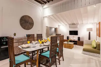 a dining room and living room with a table and chairs at Villa Nyama by Optimum Bali Villas in Seminyak