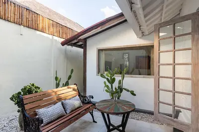 a wooden bench sitting on a patio with a table at Villa Nyama by Optimum Bali Villas in Seminyak
