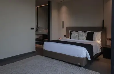 a bedroom with a large bed with black and white pillows at Black Villas Canggu Beach by OXO in Canggu