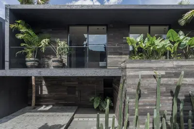 a house with plants on the side of it at Black Villas Canggu Beach by OXO in Canggu