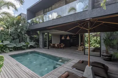 an external view of a house with a swimming pool at Black Villas Canggu Beach by OXO in Canggu