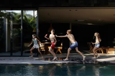 a group of children playing by a swimming pool at Black Villas Canggu Beach by OXO in Canggu