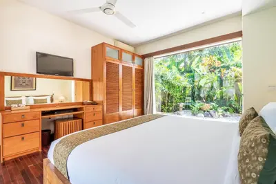 a bedroom with a large bed and a window at Villa Ku Besar by Villa Finder in Dalung