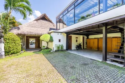 an external view of a house with a thatched roof at Villa Ku Besar by Villa Finder in Dalung