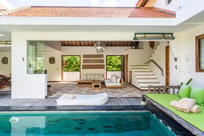 an outdoor living area with a pool and a house at Villa Ku Tama by Villa Finder in Seminyak