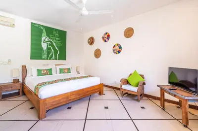 a bedroom with a bed and a flat screen tv at Villa Ku Tama by Villa Finder in Seminyak