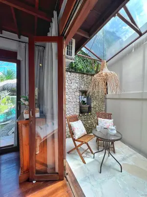 a patio with a table and chairs and a room at Villa Nicole 5BR Paradise, quiet area in Central Oberoi Seminyak in Seminyak