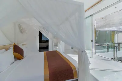 a white bedroom with a bed and a large window at Superb 3 Bed Villa, Walk to Beach, Fast Wi-Fi, in Seminyak