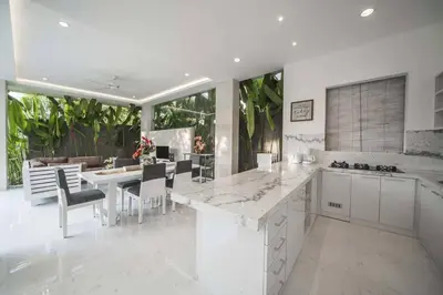 a kitchen and dining room with white cabinets and a table at Superb 3 Bed Villa, Walk to Beach, Fast Wi-Fi, in Seminyak