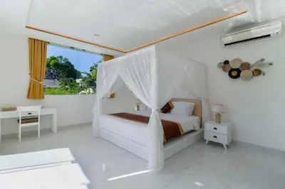 a white bedroom with a bed with a canopy at Superb 3 Bed Villa, Walk to Beach, Fast Wi-Fi, in Seminyak