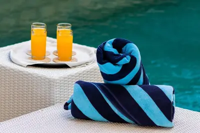 two glasses of orange juice on a table next to a pool at Superb 3 Bed Villa, Walk to Beach, Fast Wi-Fi, in Seminyak