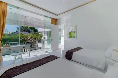a white bedroom with a bed and a window at Superb 3 Bed Villa, Walk to Beach, Fast Wi-Fi, in Seminyak