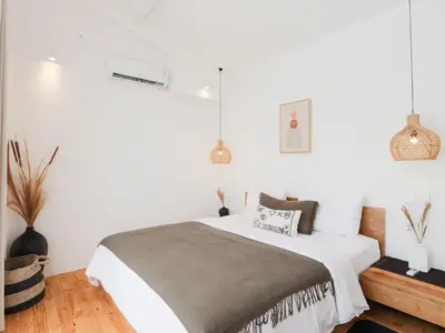 a bedroom with a bed with white walls at Berawa Village Suite in Canggu