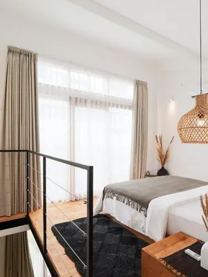 a bedroom with a bed and a large window at Berawa Village Suite in Canggu