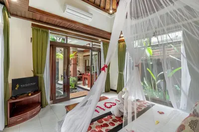 a bedroom with a bed with mosquito net at The Bali Dream Suite Villa Seminyak in Seminyak